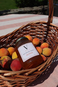 honey laying in basket of peaches outside on table