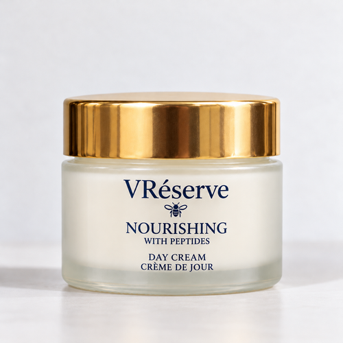 A jar of VRéserve Nourishing with Peptides Day Cream, featuring a frosted glass container, a shiny gold lid, and navy blue text on a clean white background.