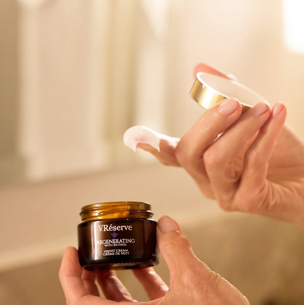 finger dipped in VRESERVE Night Cream holding lid and holding dark brown jar in other hand