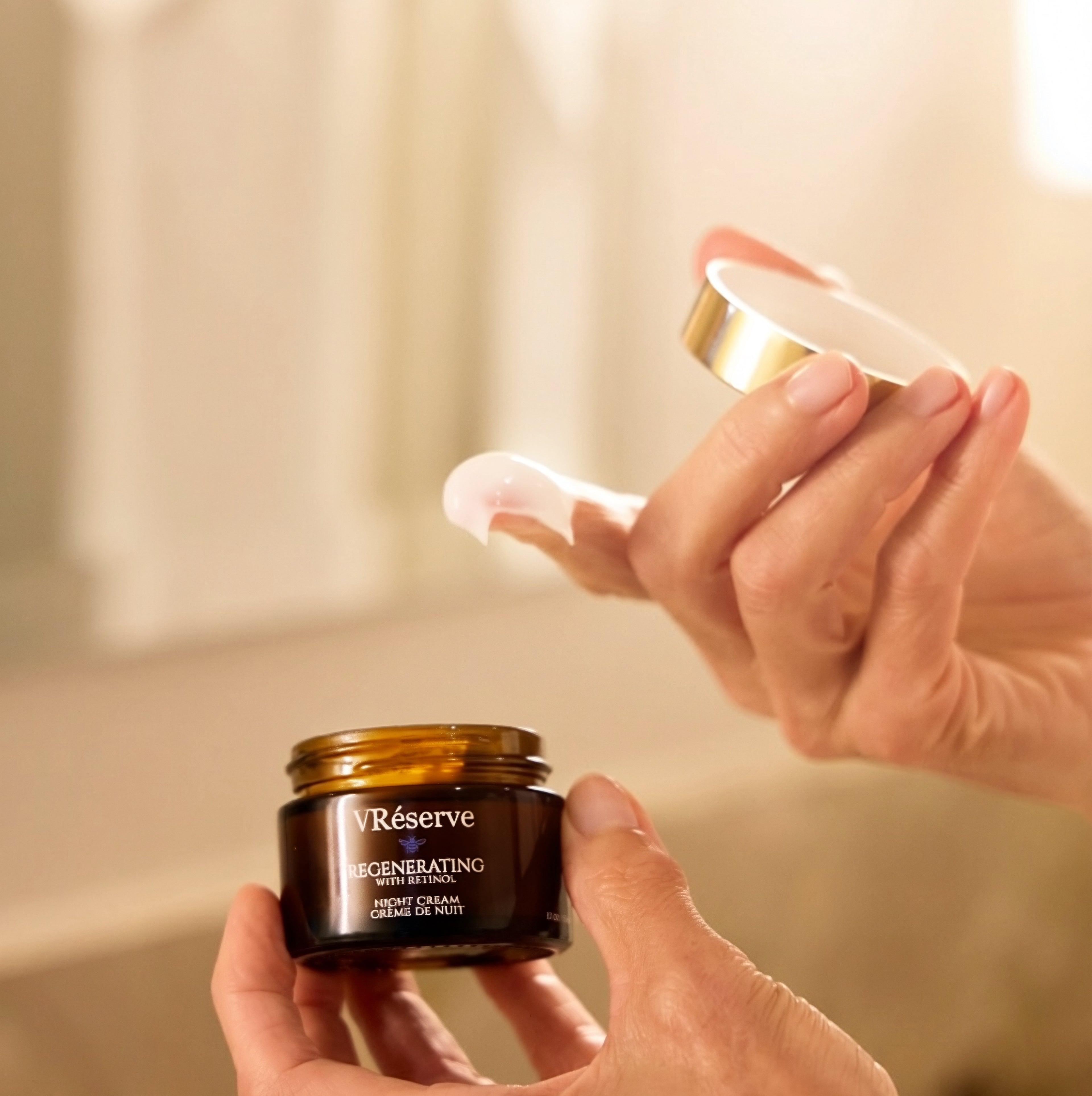 finger dipped in VRESERVE Night Cream holding lid and holding dark brown jar in other hand